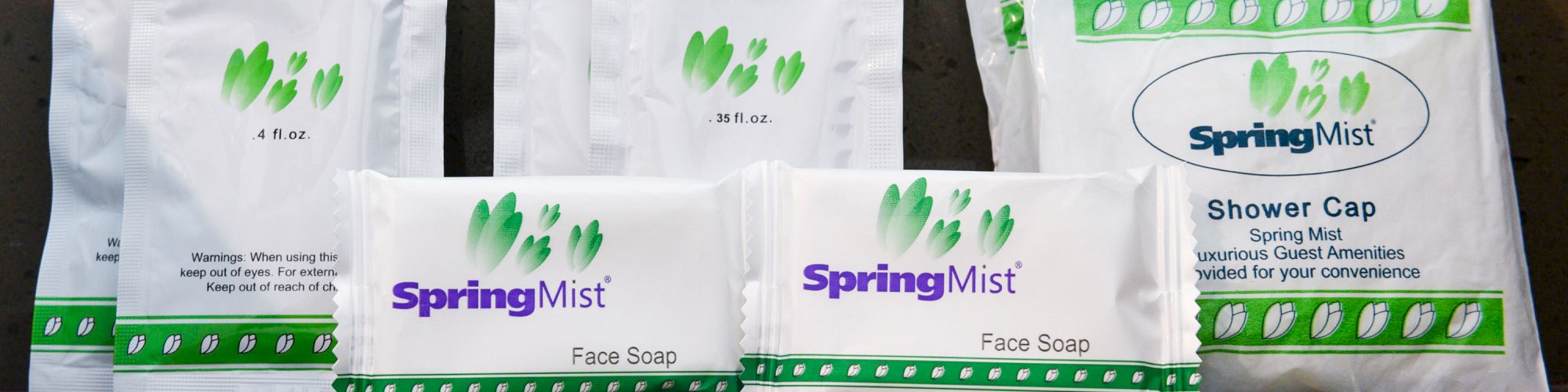 The image shows a collection of hotel toiletries including soap, conditioner, lotion, and a shower cap, all branded as SpringMist.